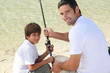 Little boy fishing with his dad
