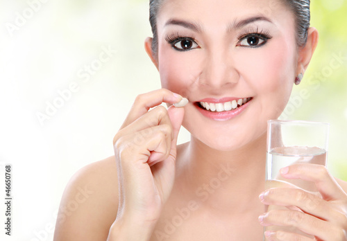 Photo: woman taking vitamin tablet woman taking vitamin tablet