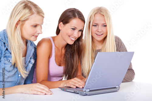 Photo: Drei attraktive junge Frauen sitzen gemeinsam vor Laptop Drei attraktive junge Frauen sitzen gemeinsam vor Laptop