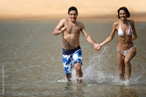 Photo: Happy couple running through the sea Happy couple running through the sea
