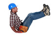 craftsman sitting on the floor and raising his legs
