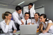 Business team gathered around laptop