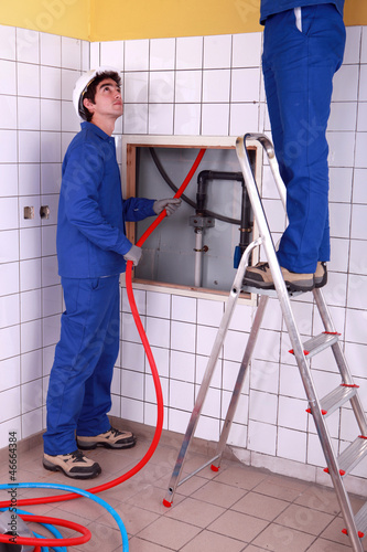 Photo: Two plumber fixing bathroom water supply Two plumber fixing bathroom water supply