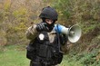 A policeman shouts orders into a megaphone