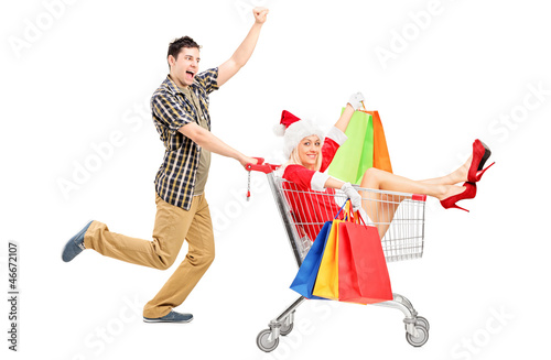 Photo: Male pushing a shopping cart and woman in christmas costume Male pushing a shopping cart and woman in christmas costume