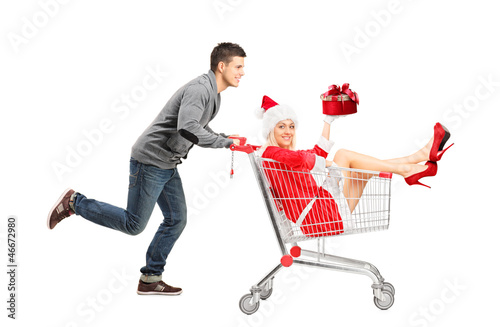 Photo: Guy pushing a female wearing christmas costume in a shopping car Guy pushing a female wearing christmas costume in a shopping car