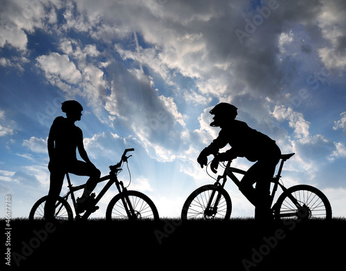 Photo: mountain bikers silhouette in sunset mountain bikers silhouette in sunset