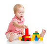 Child girl playing toy blocks and building tower. Isolated on wh