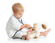 Adorable child dressed as doctor playing with toy over white