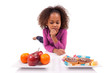 Little African Asian girl hesiatating between fruits or  candy