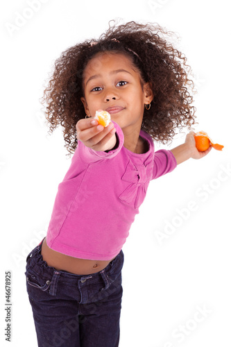 Photo: Little African Asian girl sharing a tangerine Little African Asian girl sharing a tangerine