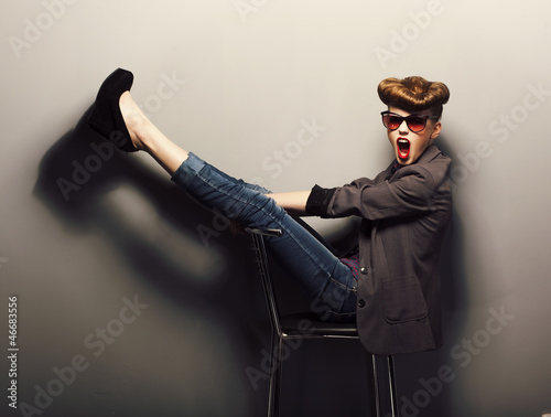 Photo: Funny girl in sunglasses on chair in studio - vintage Funny girl in sunglasses on chair in studio - vintage