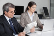 Frau am Laptop und Mann liest Zeitung