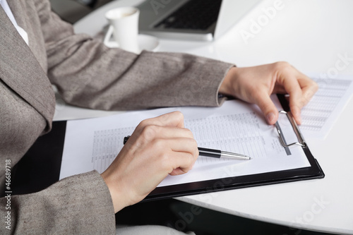 Photo: Hand mit Stift und Klemmbrett Hand mit Stift und Klemmbrett