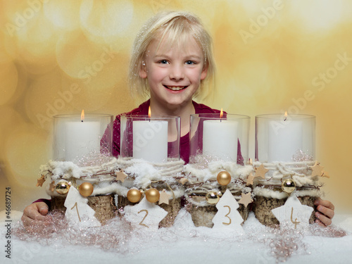 Photo: Cute blond child with Advent wreath waiting for christmas Cute blond child with Advent wreath waiting for christmas