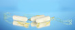 cotton tampons with yellow petals on blue background close-up