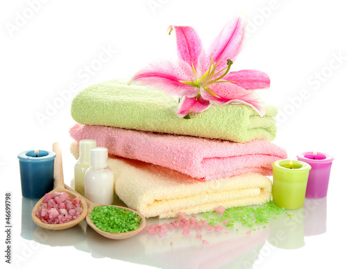 Photo: towels with lily, aroma oil, candles and sea salt isolated towels with lily, aroma oil, candles and sea salt isolated
