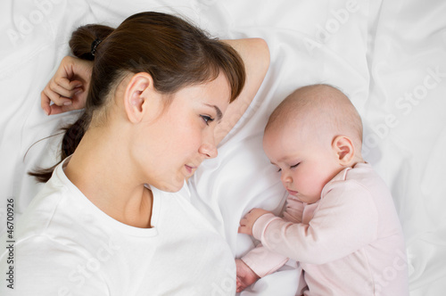Photo: Young mother looking at her sleeping baby Young mother looking at her sleeping baby