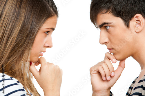 Photo: Teen coupe looking at each other wondering. Teen coupe looking at each other wondering.