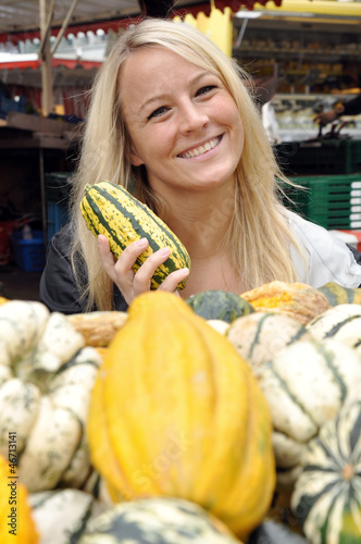 Photo: Junge Frau kauft Kürbis auf Markt Junge Frau kauft Kürbis auf Markt