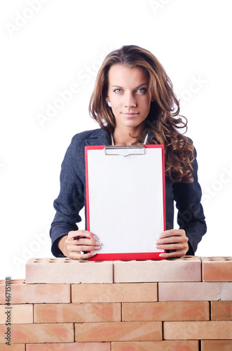 Photo: Woman builder and brick wall Woman builder and brick wall