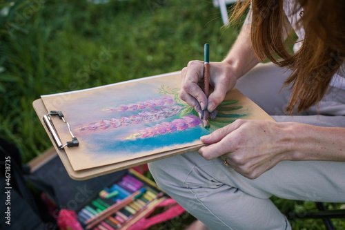 Photo: Girl draws flowers with pastels Girl draws flowers with pastels