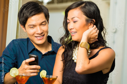 Photo: Asian man is flirting with woman in bar Asian man is flirting with woman in bar