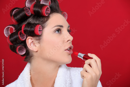 Photo: woman with curlers in her hair putting lipstick woman with curlers in her hair putting lipstick