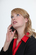 Blond office becoming stressed during telephone call