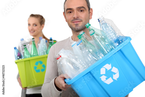 Photo: Man and woman recycling plastic bottles Man and woman recycling plastic bottles