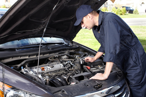 Photo: Car mechanic working in auto repair service. Car mechanic working in auto repair service.