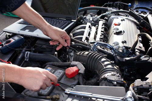 Photo: Car mechanic working in auto repair service. Car mechanic working in auto repair service.