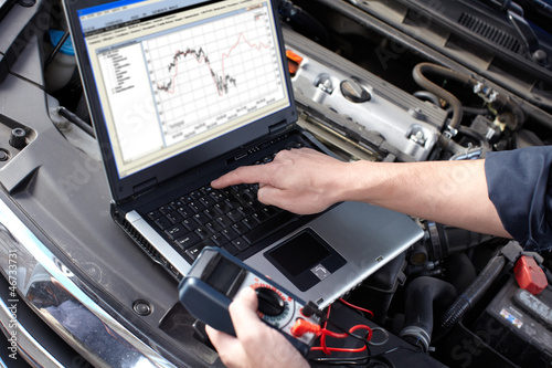 Photo: Car mechanic working in auto repair service. Car mechanic working in auto repair service.