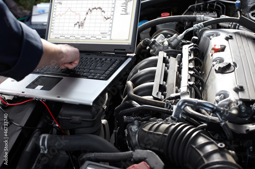 Photo: Car mechanic working in auto repair service. Car mechanic working in auto repair service.