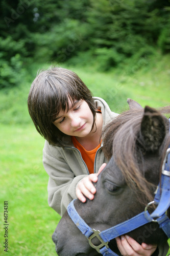 Photo: boy caressing a pony boy caressing a pony