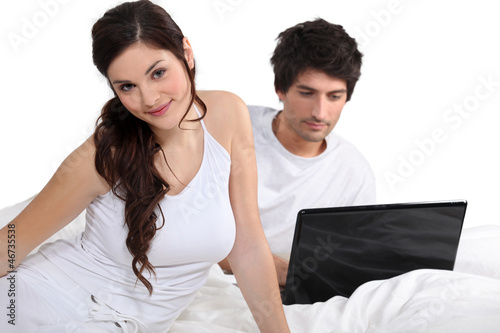 Photo: Couple in bed with a laptop Couple in bed with a laptop