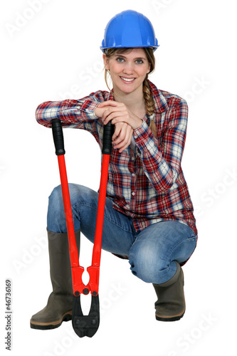 Photo: Woman kneeling by bolt cutters Woman kneeling by bolt cutters