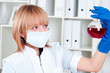 Foto: beautiful woman holds a test tube with red liquid beautiful woman holds a test tube with red liquid
