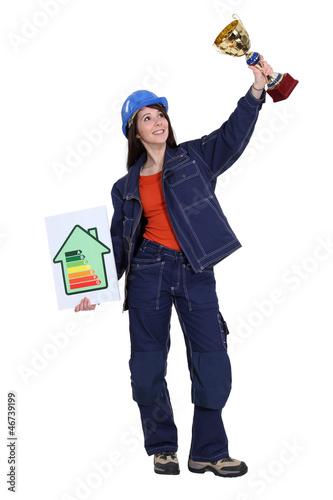 Photo: A female construction worker holding a trophy cup. A female construction worker holding a trophy cup.