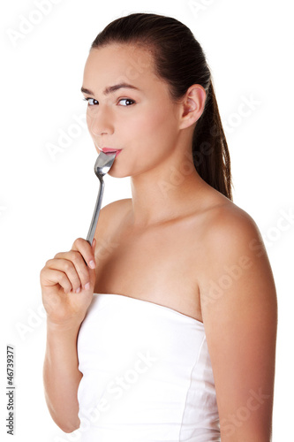 Photo: Smiling woman with spoon in her mouth Smiling woman with spoon in her mouth