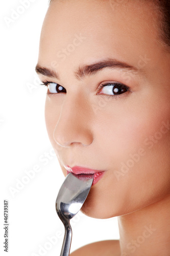 Photo: Smiling woman with spoon in her mouth Smiling woman with spoon in her mouth
