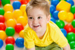 Cute kid or child playing colorful balls top view