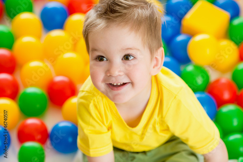 Photo: Cute kid or child playing colorful balls top view Cute kid or child playing colorful balls top view