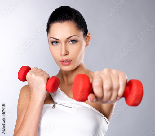 Photo: beautiful young woman with dumbbells beautiful young woman with dumbbells