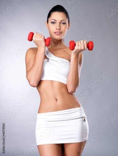 Photo: beautiful young woman with dumbbells beautiful young woman with dumbbells