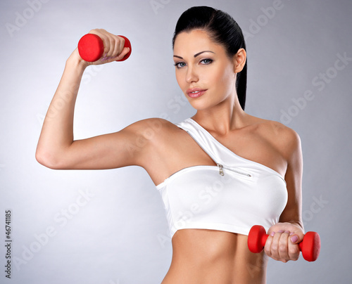 Photo: beautiful young woman with dumbbells beautiful young woman with dumbbells