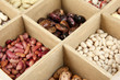 Diverse beans in wooden box sections close-up