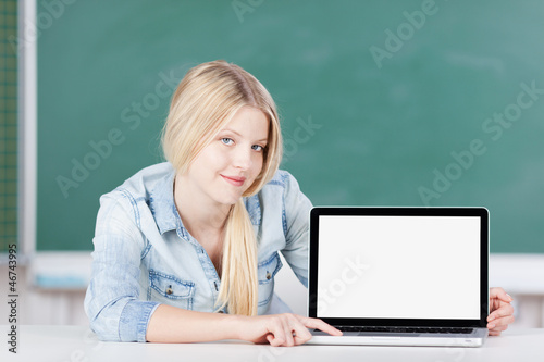 Photo: schülerin zeigt laptop-bildschirm schülerin zeigt laptop-bildschirm
