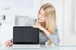 blonde frau zeigt etwas am laptop