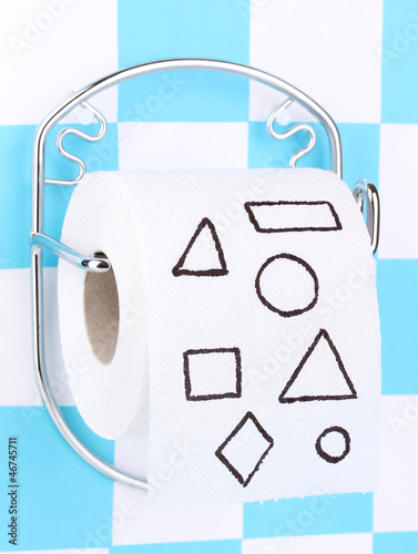 Photo: Roll of toilet paper on holder fixed to wall Roll of toilet paper on holder fixed to wall